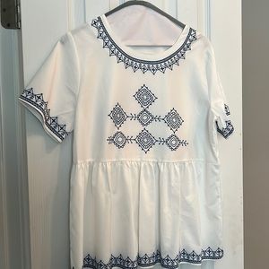 White top with printed navy embellishment.